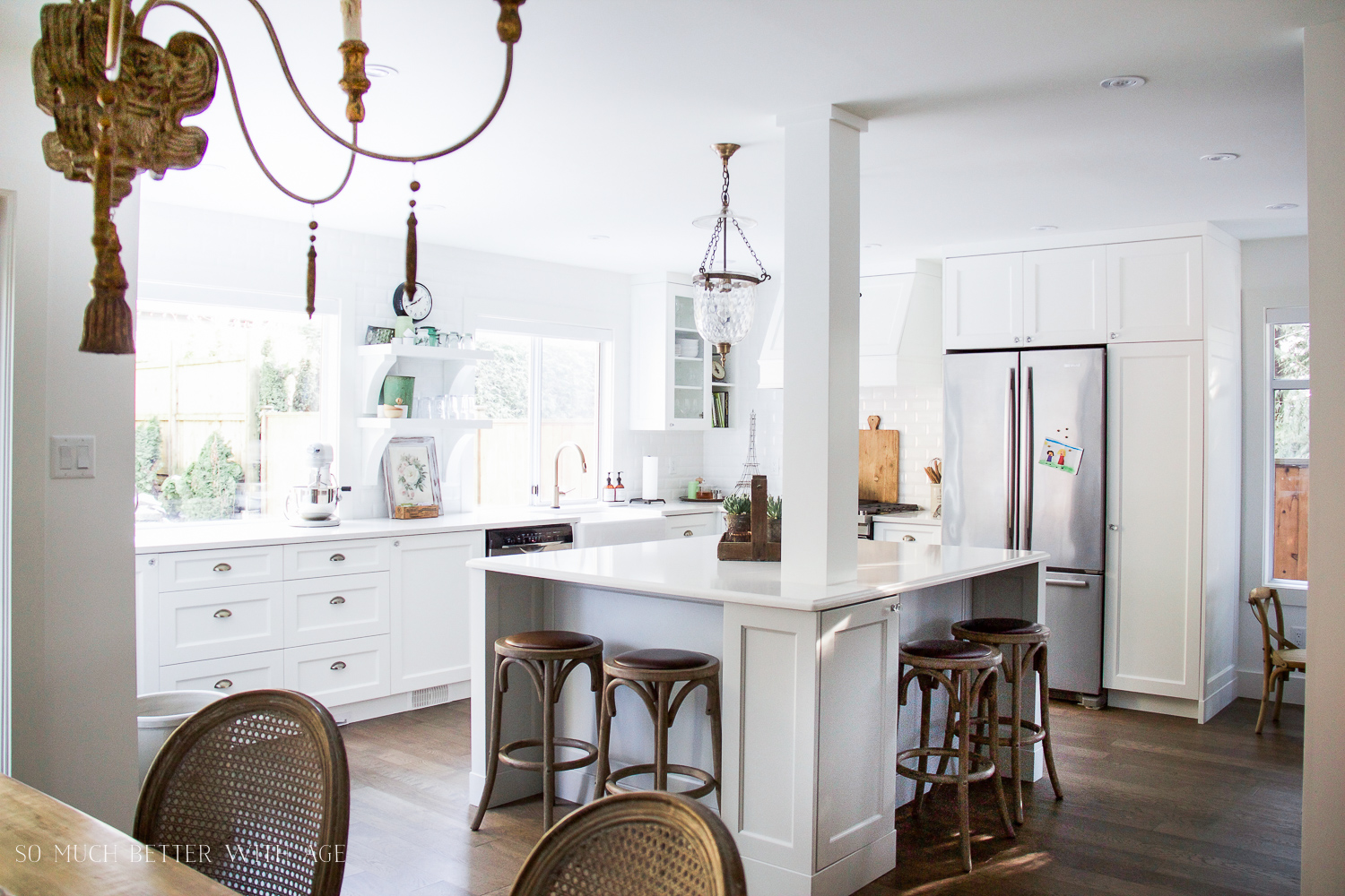  A chandelier is in the kitchen by the dining room table.