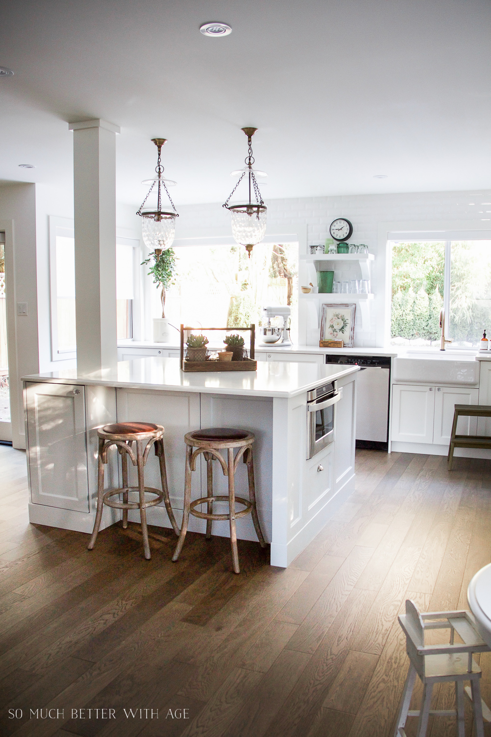 White kitchen island with plants on the island.