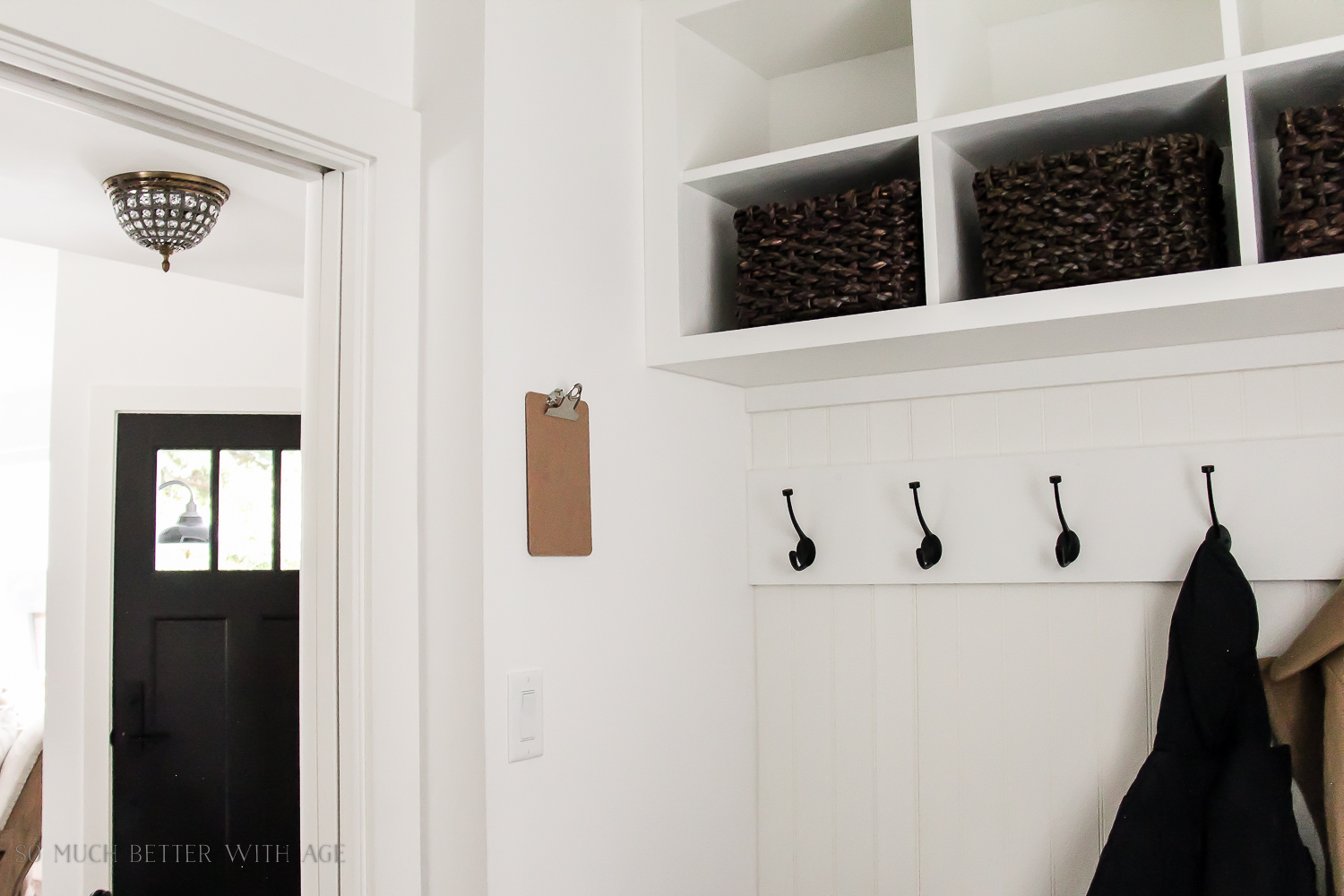 Cubby holes with dark baskets by the front door.