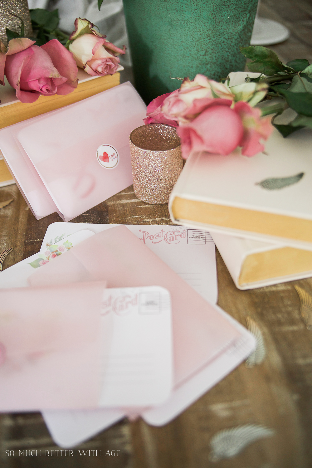 Valentine's Day cards on a wooden table beside old books.