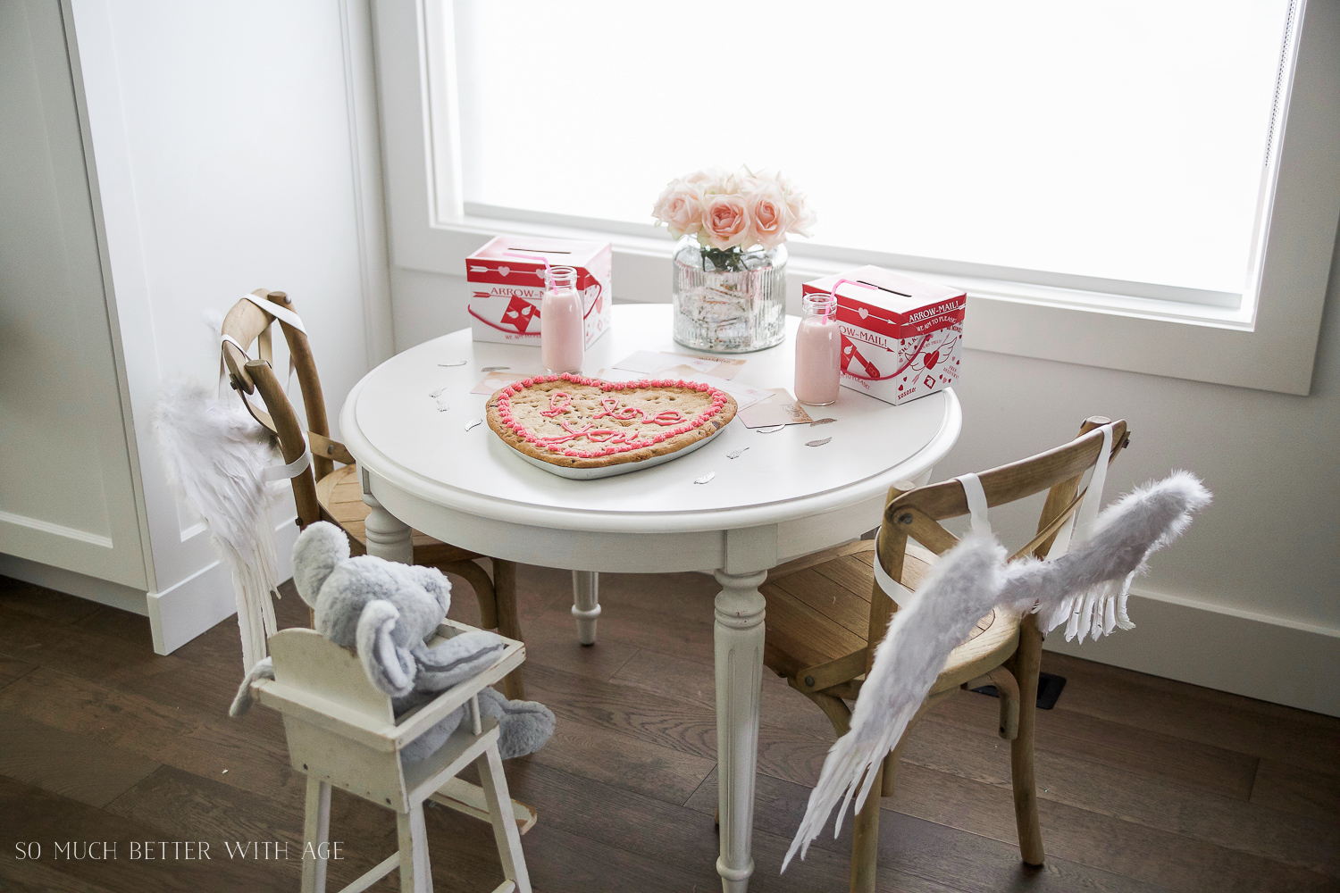 There are fluffy angel wings on the chairs by the table.