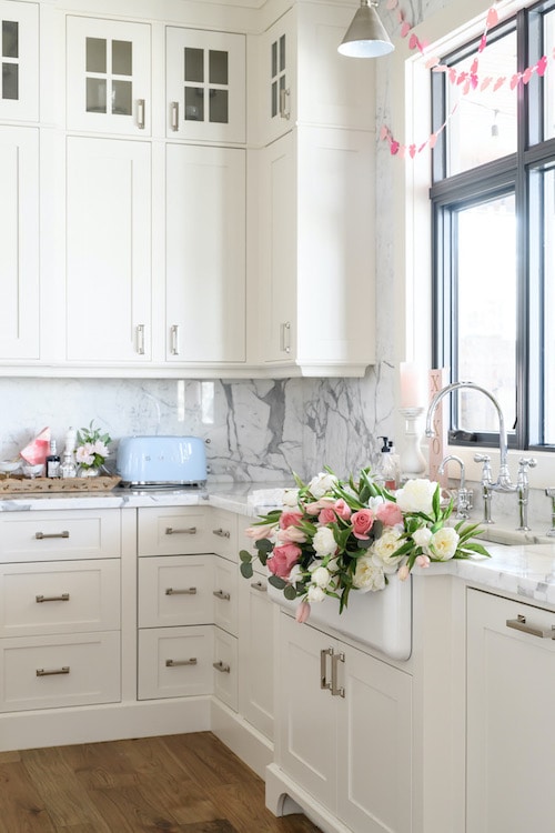 Pink and white roses on a white kitchen sink.