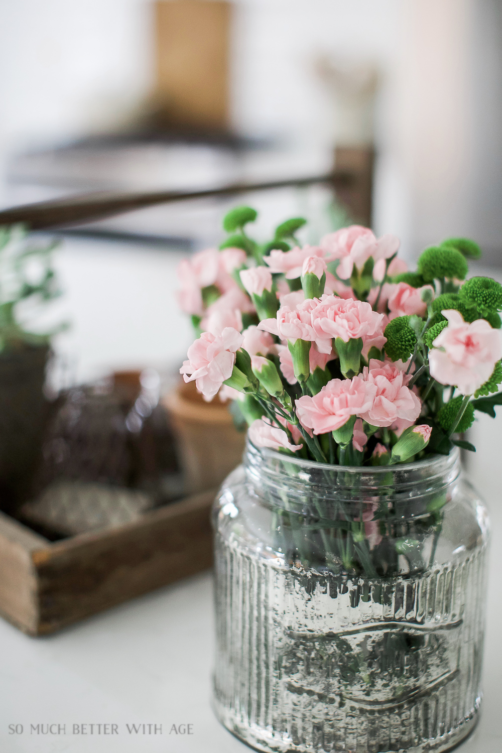 Pink flowers in mercury glass container.