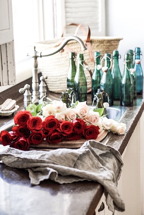 Red and white roses beside the sink in the kitchen.