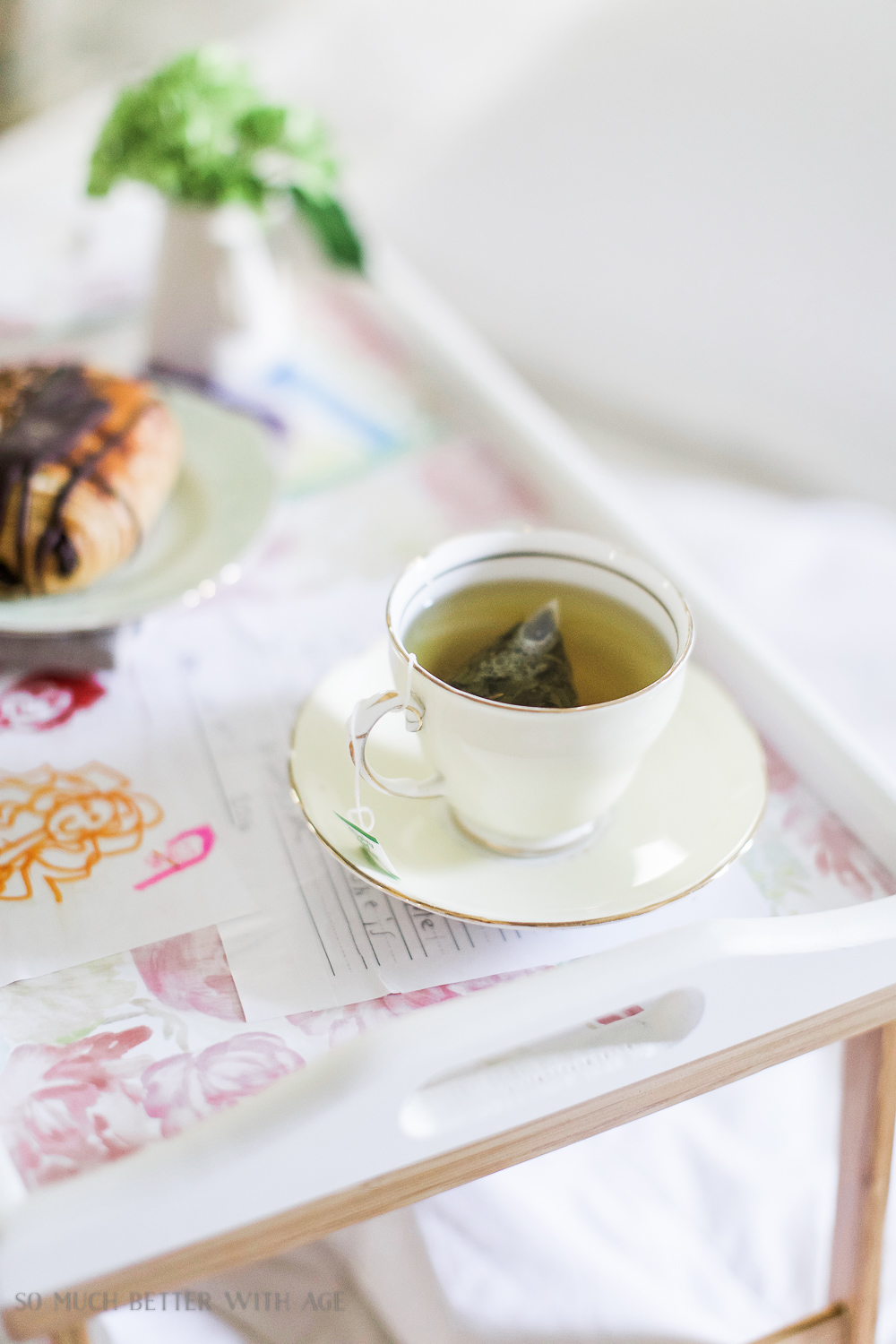 A cup of tea on the tray with a teabag in the cup.