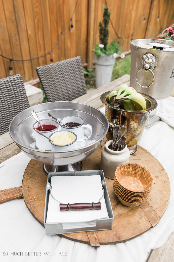 Ice cream party fixings on table outdoors. 