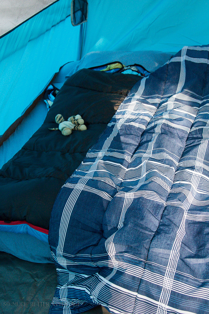 Stuffed toy animal on bed in tent.