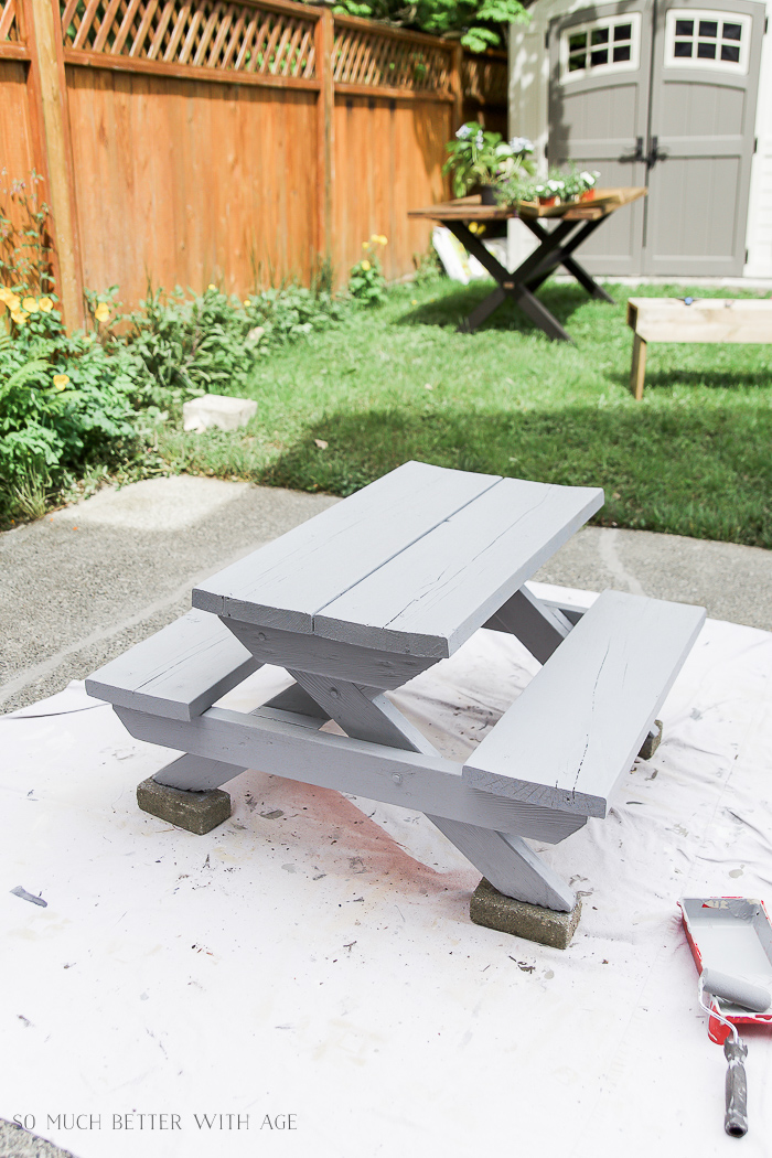 The first coat of paint on the small picnic table.