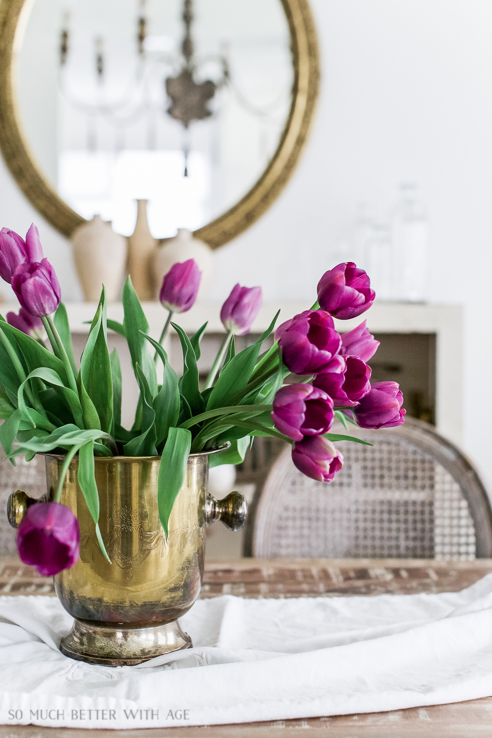 Up close look at the purple tulips in a champagne bucket on the table.