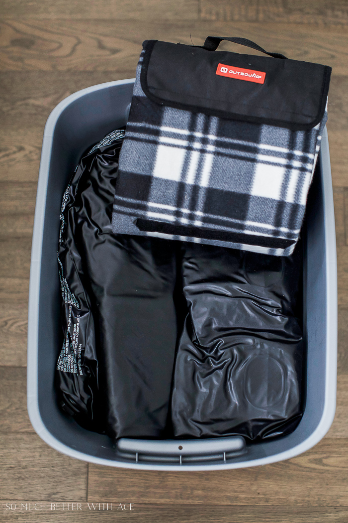 Blanket and air mattress in blue bin.