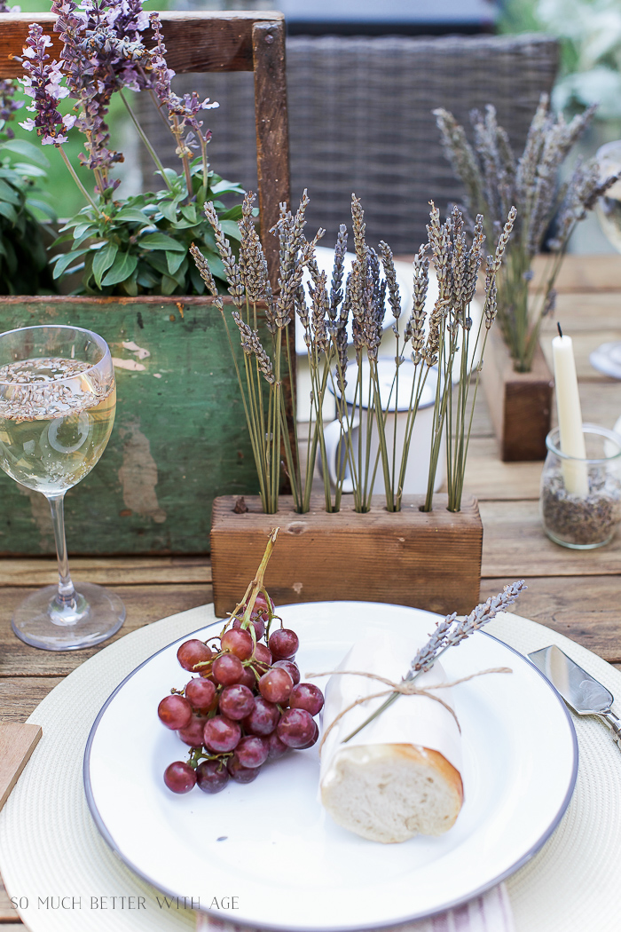 Outdoor table setting with lavender and grapes on a plate.