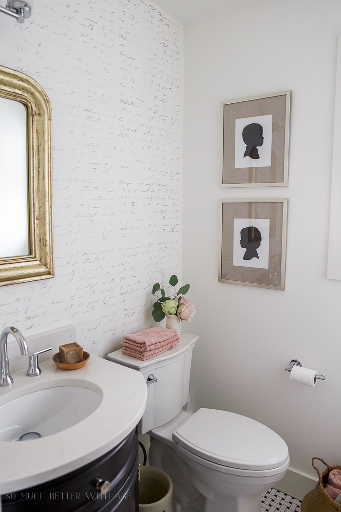 Two silhouette pictures hanging in the bathroom.