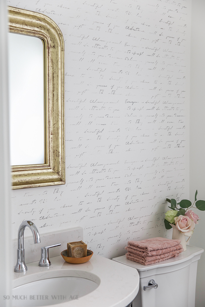 A french gold mirror is in the bathroom.