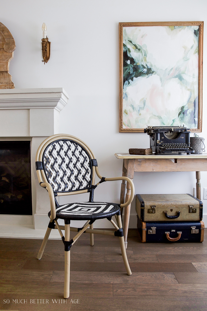 There is a painting behind the typewriter in the living room.