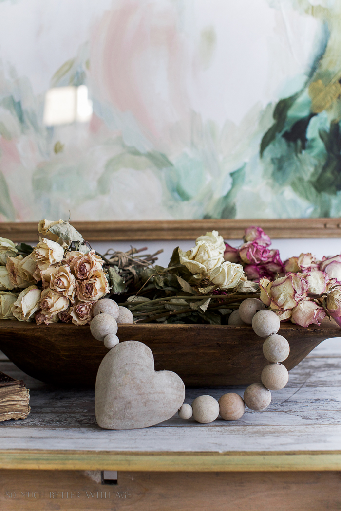 Dried roses, and wooden prayer beads on the table.