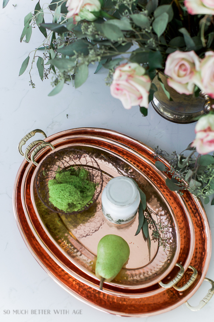 Copper platters and a pair on the island in French vintage kitchen.