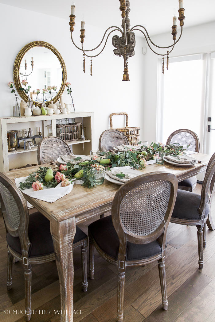 Dining room table decorated with roses, pears and eucalyptus.