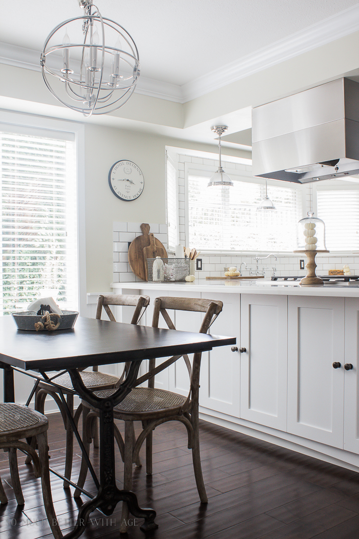 White kitchen with a dark wood table and wooden chairs.