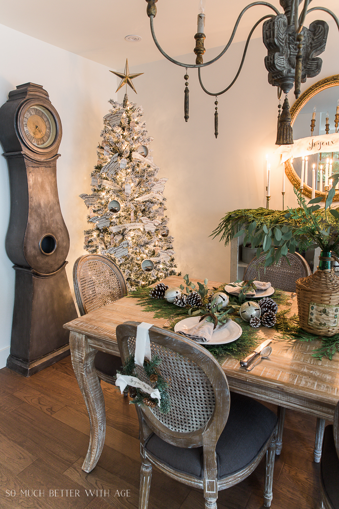 A Mora clock behind the table, a flocked Christmas tree beside it.