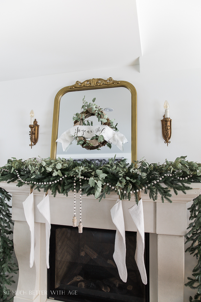 There are white stockings hanging by the fireplace mantel.