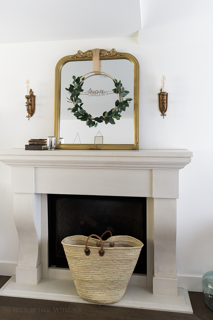 A gold mirror with the hoop wreath on it tied with a gold ribbon.