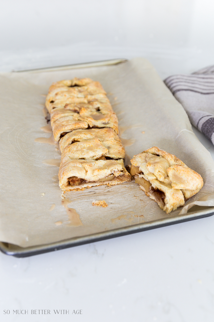 Rustic Apple Strudel on parchment paper with a piece cut to eat.