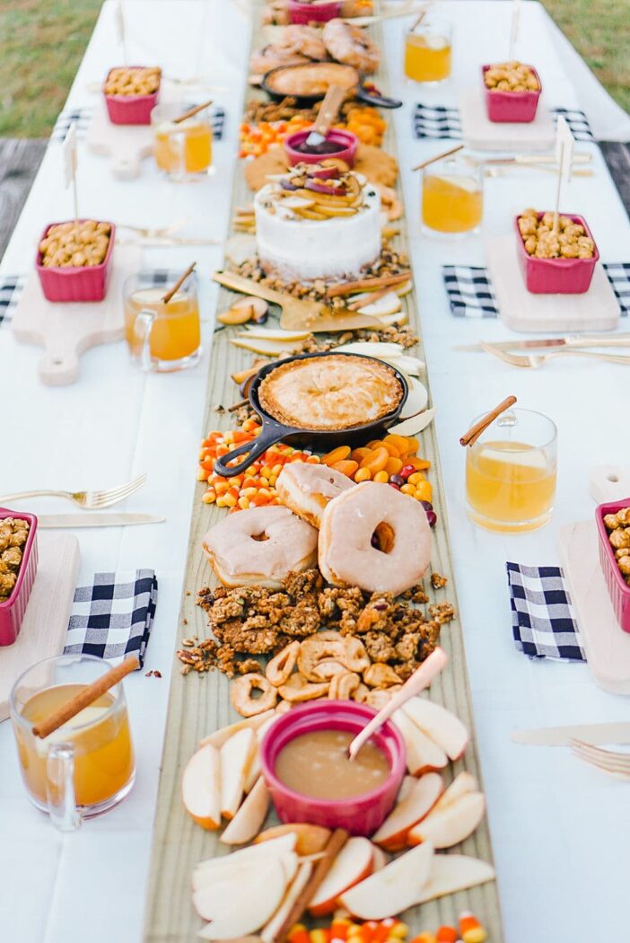 Dessert board with donuts and pies in skillets on a picnic table by Best Friends for Frosting. 