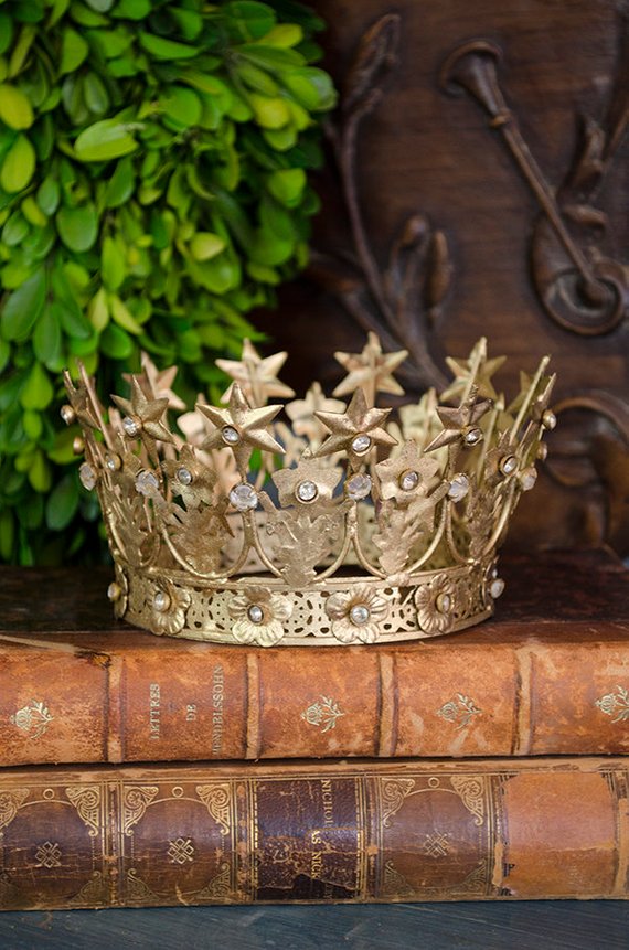 Golden crown on stack of vintage books by Edith & Evelyn.