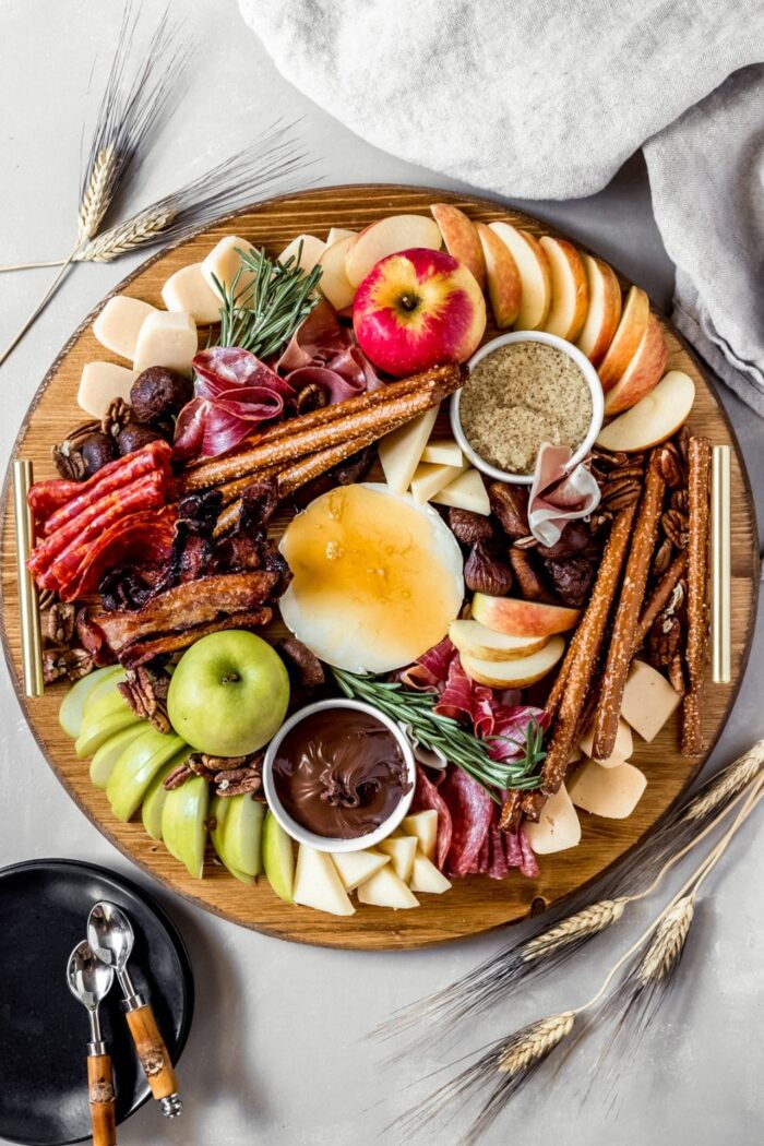 Charcuterie board with apples, bread sticks, nutella, meat, and cheese from Wanderlust and Wellness. 