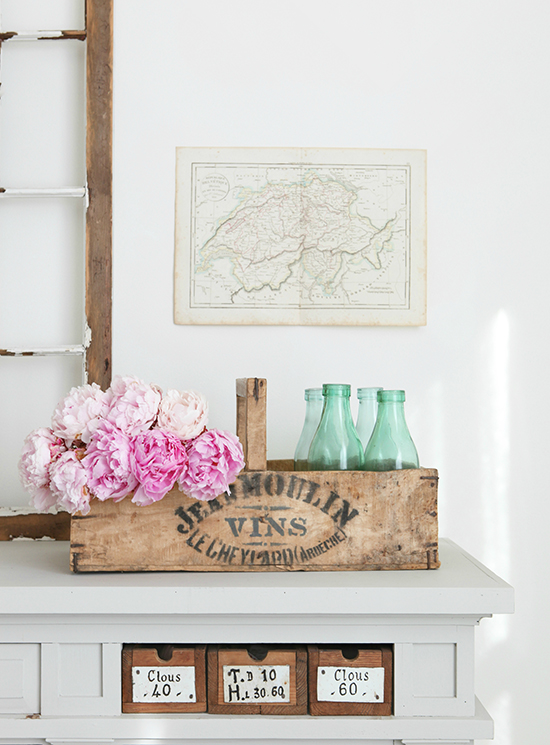 Wooden crate and green glass bottles and peonies by French Larkspur.