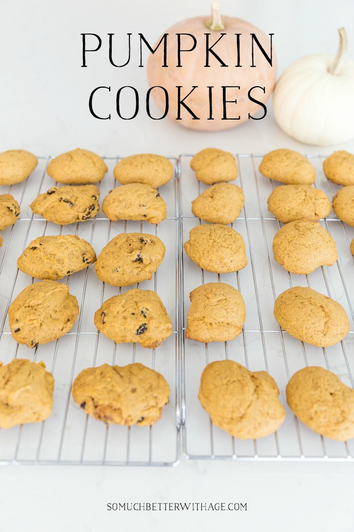 Pumpkin cookies on a baking rack with an orange and white pumpkin behind them.