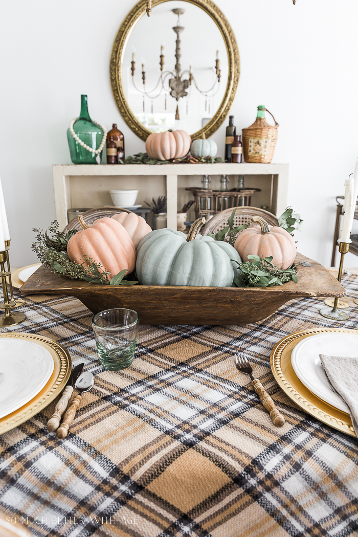 Plaid tablecloth and pumpkins on table.