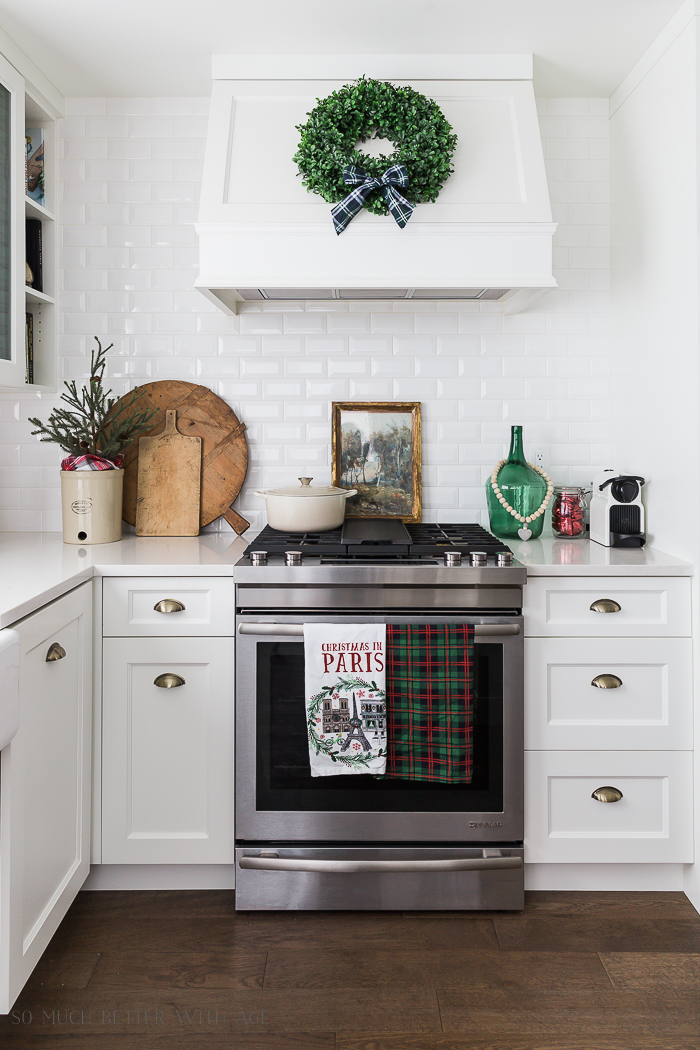 A green wreath with a flannel bow on the range hood.