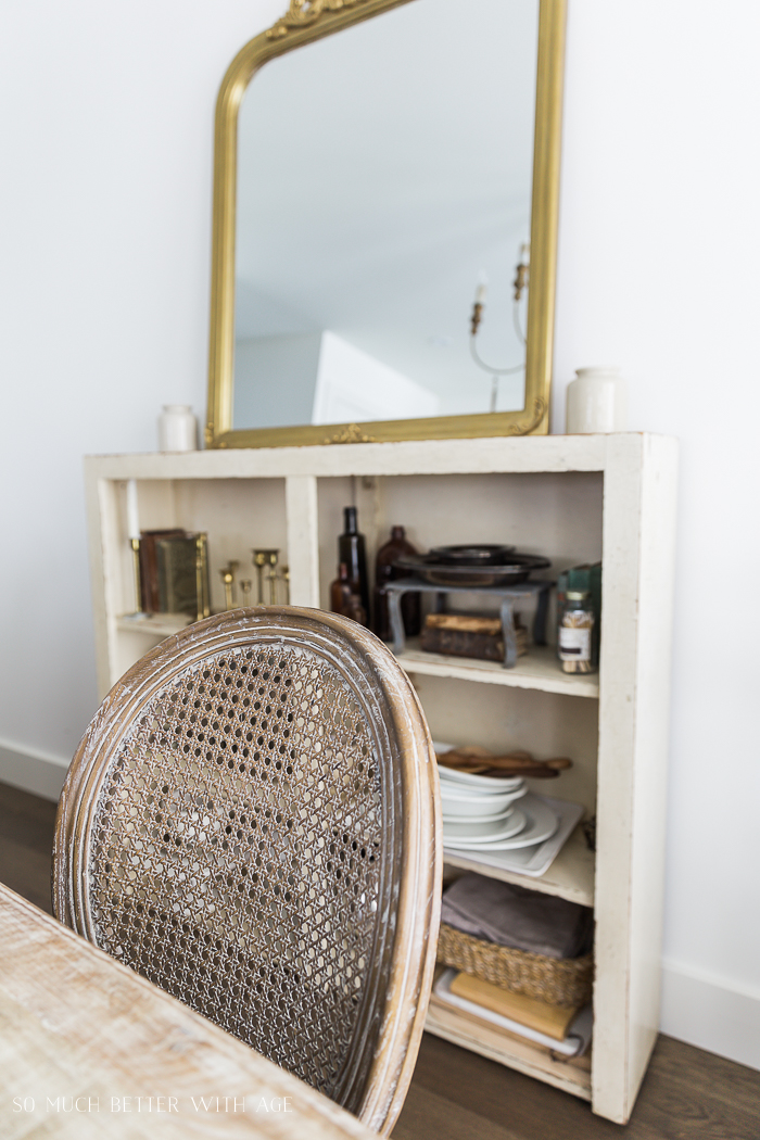 A dining room chair and the shelving unit behind it.