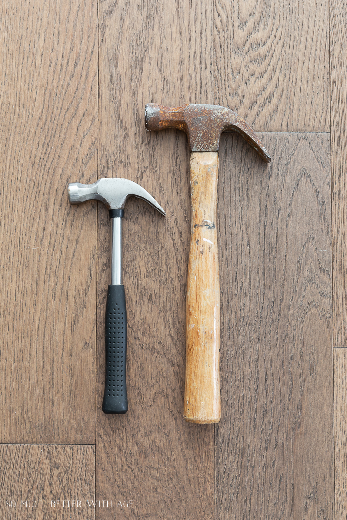 Two hammers lying on the floor side by side.