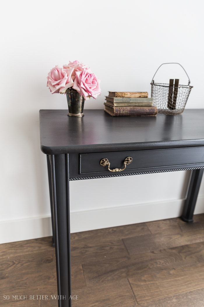 Pink flowers on the charcoal grey desk.