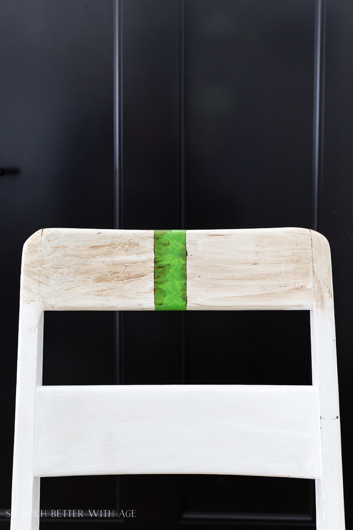 The white chair with 2 different waxes on it with green tape in the middle.