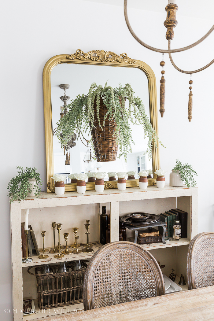 Spring Dining Room with Greenery and Gold/basket on mirror above a console shelf.