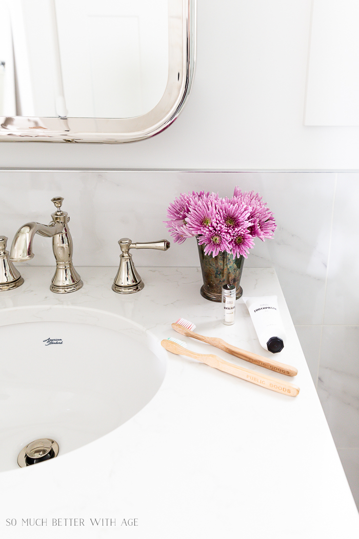 A small vase of purple flowers on the vanity.