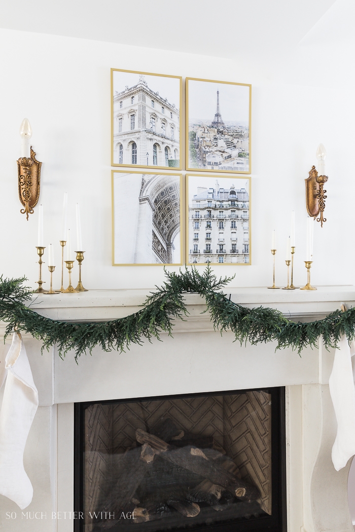 Green garland on mantel with four Paris images in frames. 