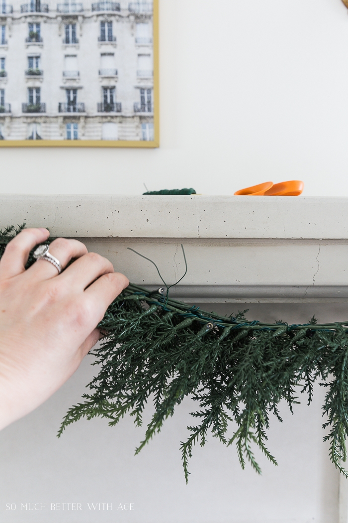 Hand holding garland and tying it together.