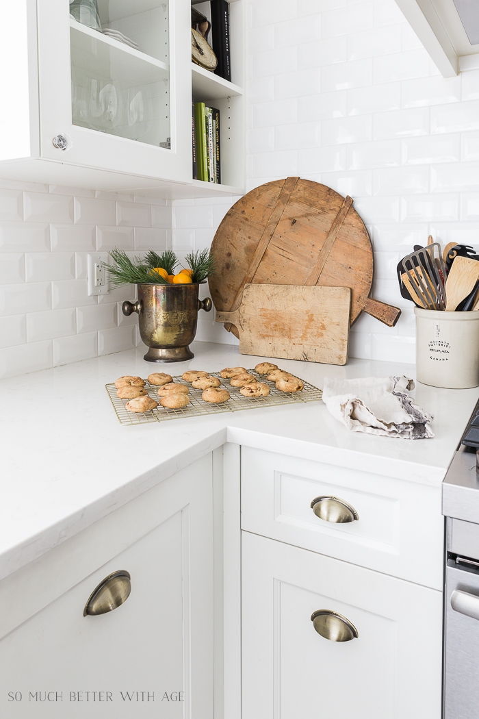 French bread boards on counter with cookies and bucket with oranges. 