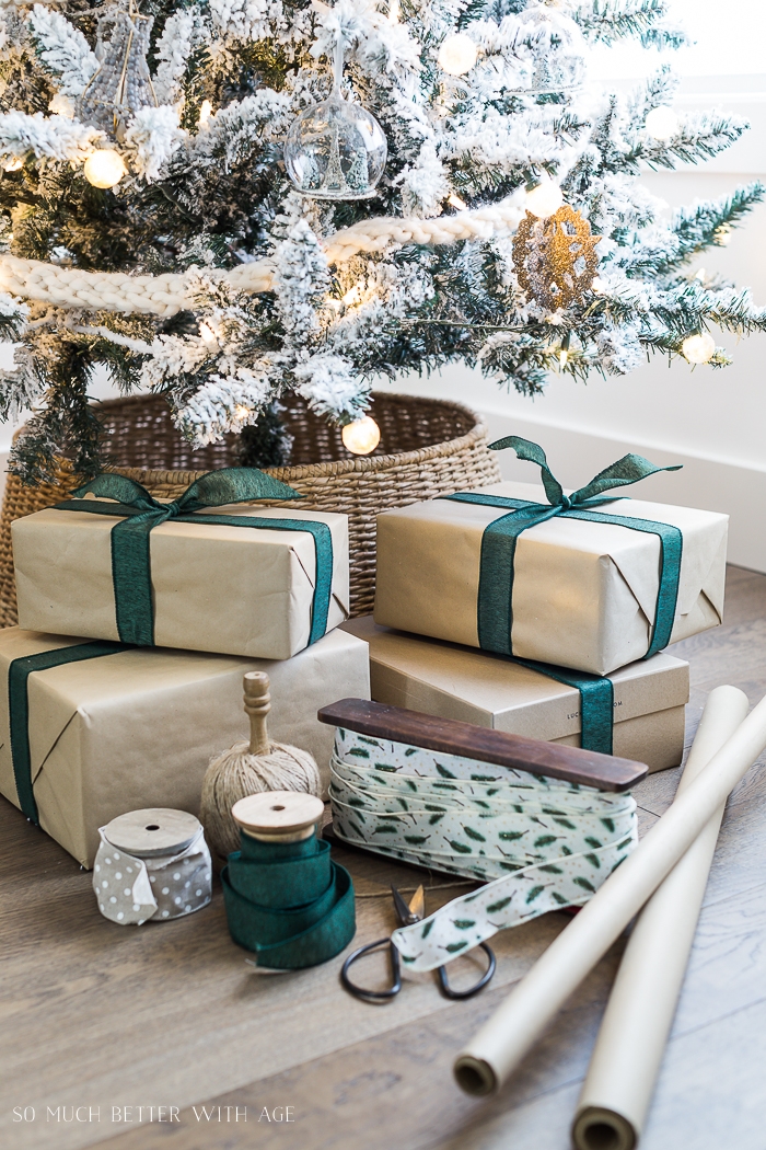 Presents wrapped with kraft paper and green bow under the tree. 