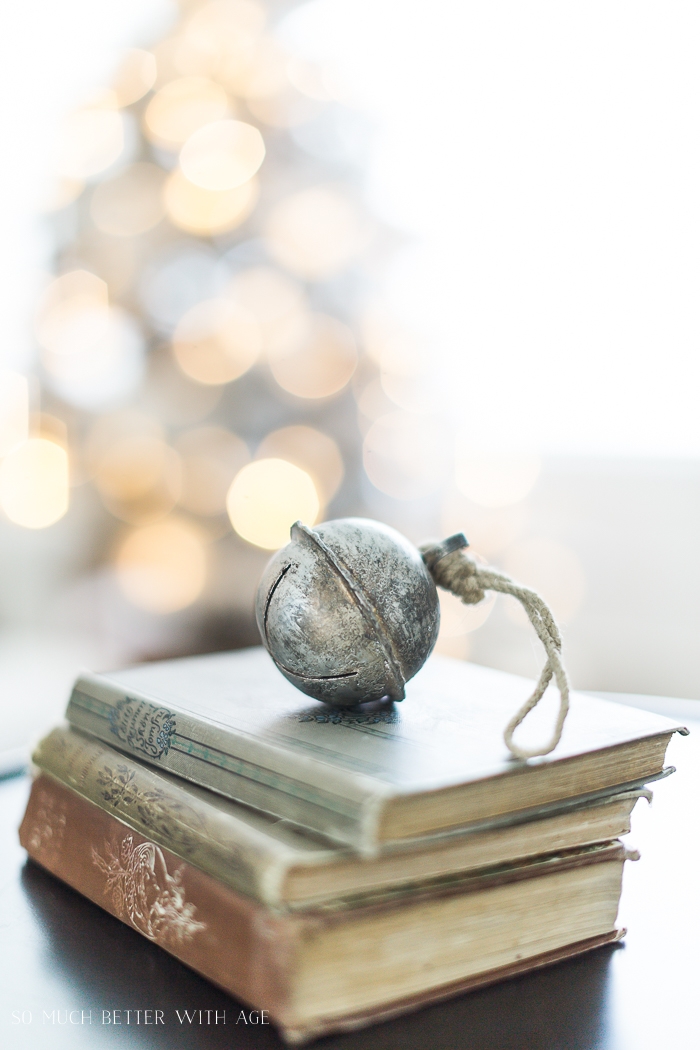 Jingle bell on old books with bokeh lights in background. 