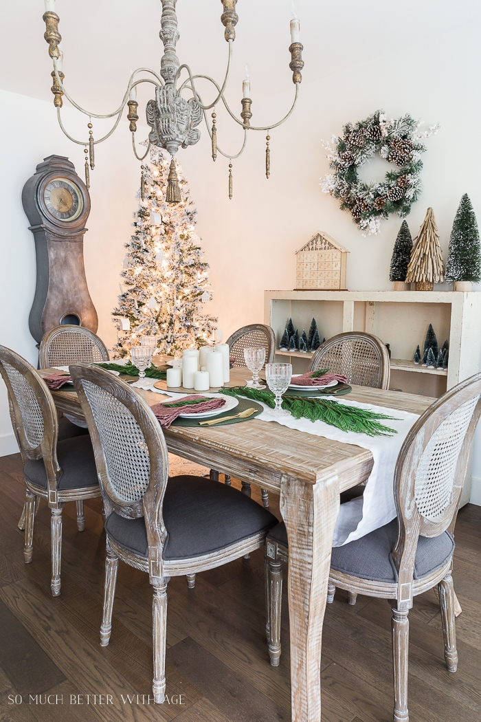 French chandelier and cane backed chairs in dining room decorated for Christmas. 