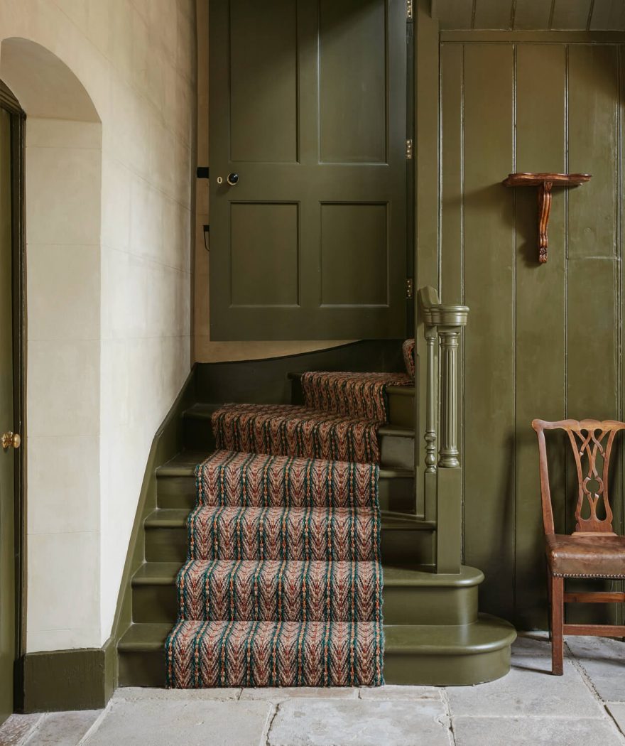 Green stairs, green painted walls and red carpet runner.