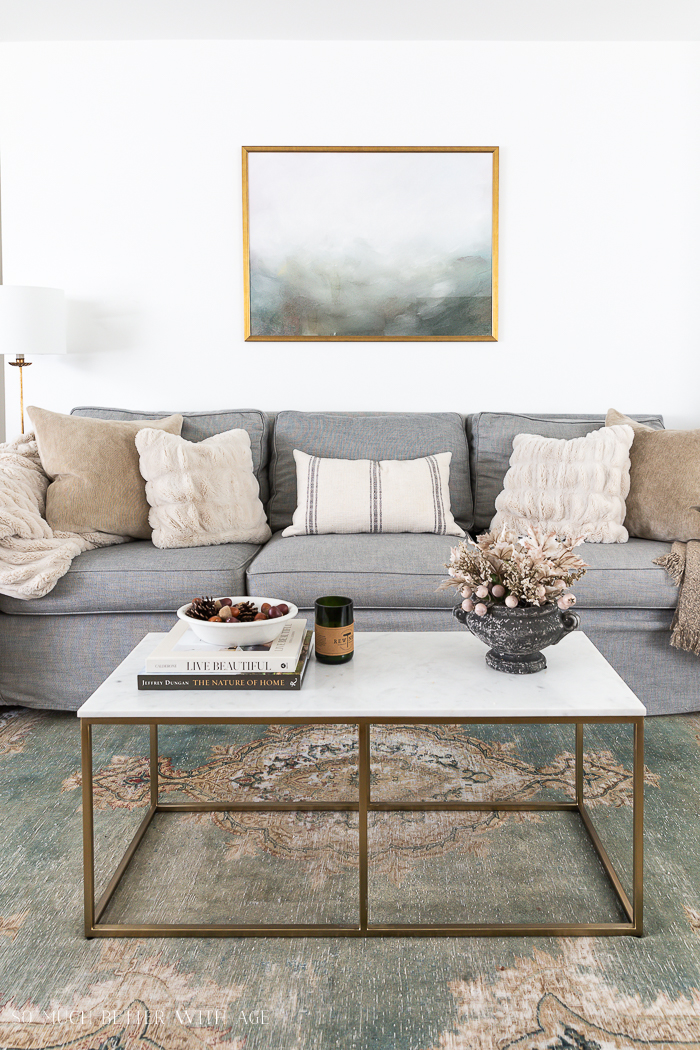 A grey couch in the living room with a white coffee table.