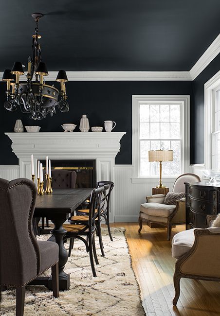 A formal dining room with the walls painted black and white.