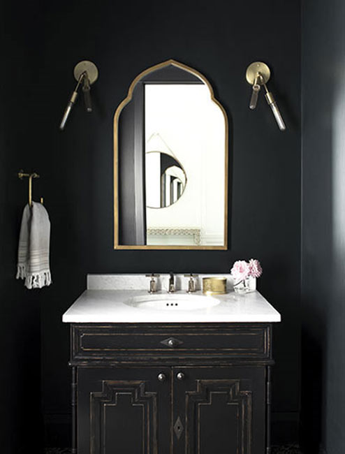 A bathroom with dark walls and cabinet.