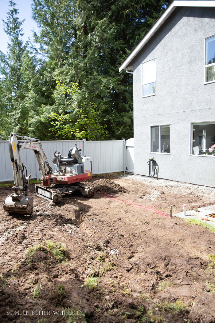 Excavator grading back yard.